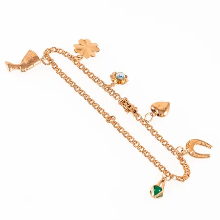 Armband Bismarck i 18K guld med 6 berlocker: Hästsko, Nefertiti, fyrklöver. Det är 20 cm långt, 3 mm brett och väger 7,9g. Kistlås. Ögla från berlock hänger kvar.
