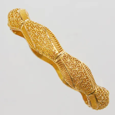 Armring med genombruten dekor yttre Ø70mm, innre Ø58mm, bredd 7-11,5mm, 18K Vikt: 13,3 g