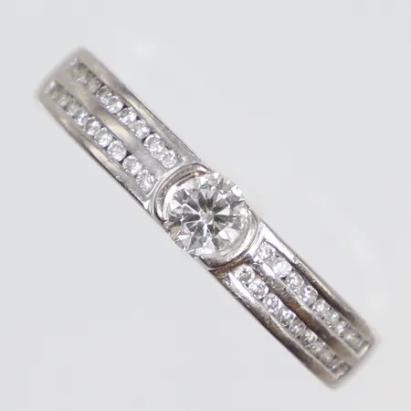 Ring i vitguld med diamanter 1x0,18ct samt 36xca0,005ct stl:16¼ bredd 3mm gravyr 18K Vikt: 4,6 g