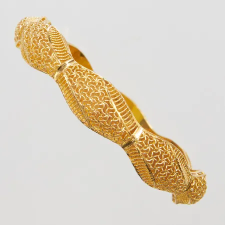 Armring med genombruten dekor yttre Ø69mm, innre Ø58mm, bredd 7-11,5mm, 18K Vikt: 13 g