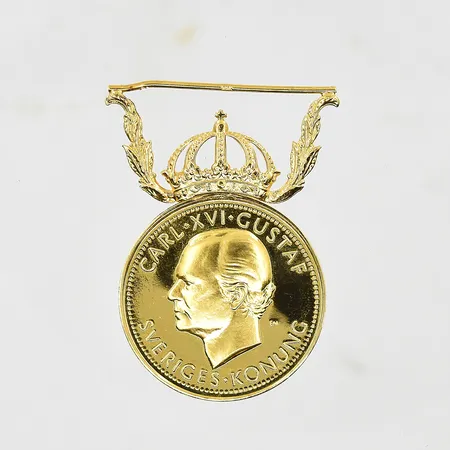 Förtjänstmedalj Carl XVI Gustaf Ø27 mm, namngravyr, viktfördelning fäste 18K ca 3,6g 23K ca 10g.