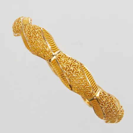 Armring med genombruten dekor yttre Ø69mm, innre Ø58mm, bredd 7-11,5mm, 18K Vikt: 12,9 g