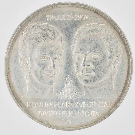 Jubileumsmynt Kungliga bröllopet 19 Juni 1976 Konung Carl XVI Gustaf Drottning Silvia Nominellt värde 50kronor Ø36mm, 925/1000 silver Vikt: 27,2 g