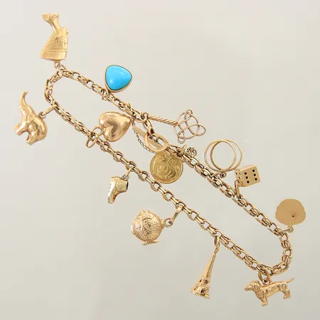 Armband med 13 berlocker längd ca 21,5cm, bredd 3,1-11,5mm, en berlock i 14K, säkerhetskedja, mindre bucklor, 18K Vikt: 20,1 g