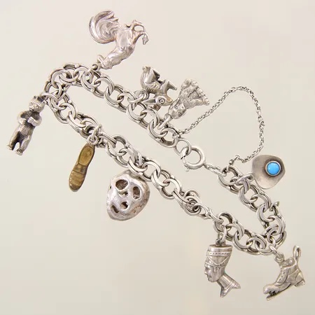 Armband Bismarck med åtta berlocker längd ca 21cm, bredd 1-7mm, en berlock saknas samt en i vitmetall, silver 830/1000 Vikt: 27,4 g