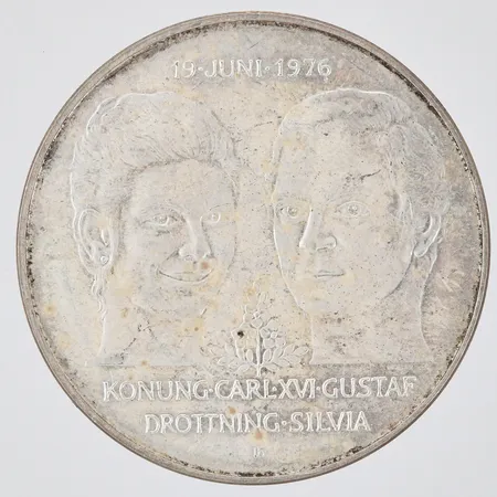 Jubileumsmynt Kungliga bröllopet 19 Juni 1976 Konung Carl XVI Gustaf Drottning Silvia Nominellt värde 50kronor Ø36mm, 925/1000 silver Vikt: 27 g