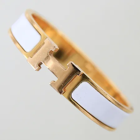 Armband Hermés Clic H gulmetall med vit emalj 55x45mm bredd 12mm emalj med slitage gulmetall med repor samt H med lätt färgbortfall kvitto från NK 2015 dustbag etui