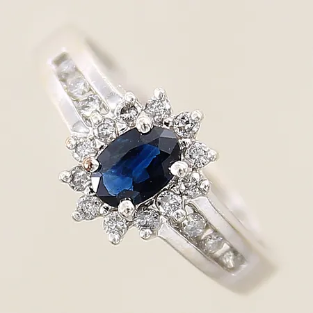 Carmoséring med troligen syntetisk blå safir samt diamanter 12 x ca0,01ct 6 x ca 0,02ct stl: 17¼, bredd 2,1-10mm vitguld 10K Vikt: 2,9 g
