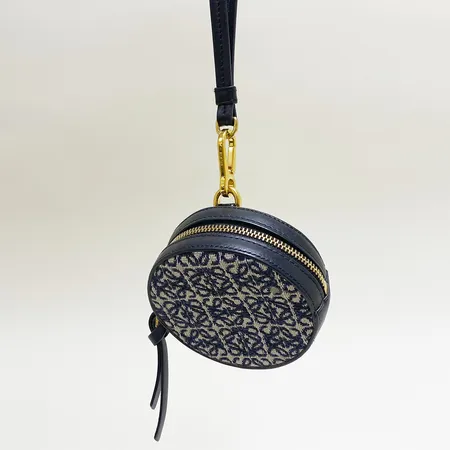 Portmonoä Loewe Anagram cookie pouch, Ø90mm, bredd: 32mm, beslag gulmetall, svart läder, tyg, fläckig, serie nr 102139, märkt Made in Spain, kvitto från Loewe NK daterat juli-2022