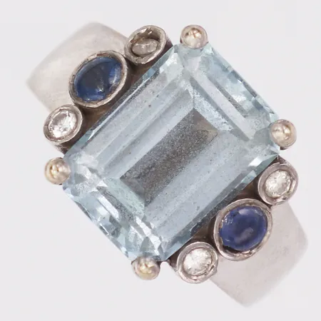 Ring diamanter 4 x ca0,03ct troligen safirer, ljusblå sten stl:19½ bredd 4,6-14,5mm, en diamant sitter löst vitguld, 18K  Vikt: 13 g