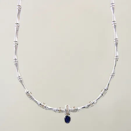 Collier med bruntonade diamanter 22 x ca 0,01ct samt blå safir längd 43cm, bredd 1,7-5,2mm, safir med minimala nagg, halvstelt, vitguld 18K Vikt: 25,7 g