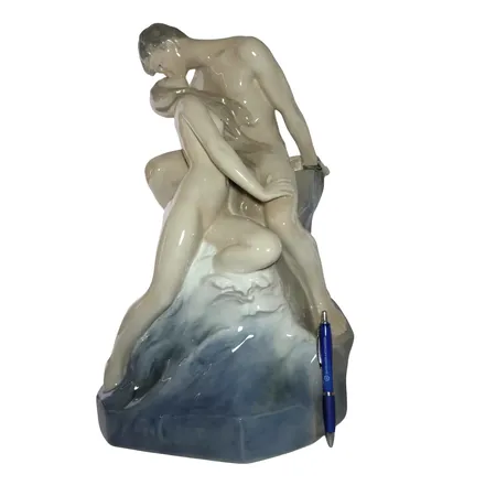 PRAKTFIGURIN "Kyssen" Royal Copenhagen Danmark ("Bolge og Strand"), porslin med polykromt underglasyrmåleri, monogramsignerad Theodor Lundberg och daterad 1897, märkt Royal Copenhagen Nr. 1132, 4:e sortering, fin lyster, höjd 46,5 cm, vikt omkring 8,4 kg, noggrant genomgången, skick utan anmärkning, skickas ej enbart avhämtning på kontoret i Kristianstad Specialfrakt, kontakta pantbankskontoret för mer information.