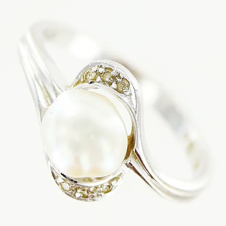 Ring vitguld med odlad pärla och diamanter 6 x ca 0,005ct, stl:16¾, bredd 2-10mm, limrester under pärla, 18K Vikt: 2,4 g