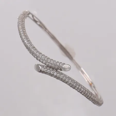 Stelt armband med stenar, ca Ø56mm bredd 2,4-8,3mm, vitguld, en sten saknas vid låsåtta. 18K Vikt: 8,4 g