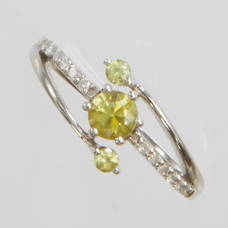 Ring med titanit 1 x 4,25mm, 2 x 2mm samt diamanter 12 x ca.0,005ct, stl:17½, bredd: 1,6-8mm, liten spricka i skenan, vitguld, 9K Vikt: 2,4 g