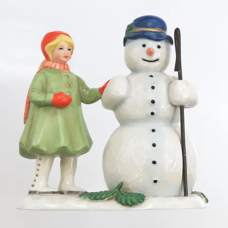 Figurin i porslin, ur serien "Helga natt" från Fyrklövern, formgiven av Barbro Rydholm, flicka och snögubbe, höjd 9cm, bredd 8cm. Skickas med postpaket.
