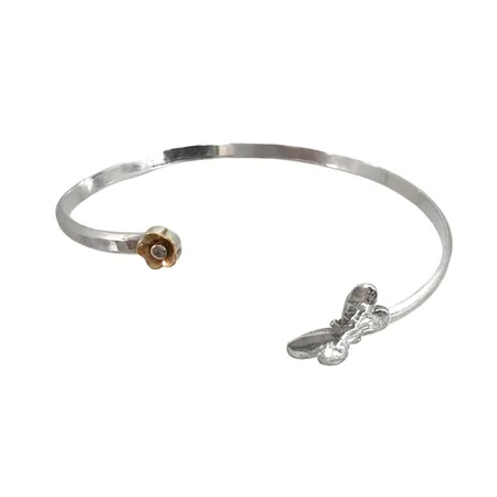Armring i silver med dekor av fjäril och lätt förgylld blomma, vit sten med slitage, hamrad skena, inre mått 17,5 cm, något justerbar, skena bredd 3 mm Vikt: 7,2 g