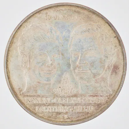 Jubileumsmynt Kungliga bröllopet 19 Juni 1976 Konung Carl XVI Gustaf Drottning Silvia Nominellt värde 50kronor Ø36mm, 925/1000 silver Vikt: 27,2 g