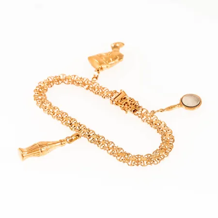 Armband x-länk i 18K guld med tre berlocker bla en handspegel (med spegelglas i metall). Längd: 17 cm. Bredd 6 mm. Kistlås. Vikt 11,6g Vikt: 11,6 g