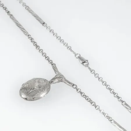 Collier i silver med en medaljong i ett fast mittparti. Längd 60 cm. Bredd 3,2 mm. Medaljongen är 35 mm lång inkl. ögla. Vikt 19,0g 925/1000