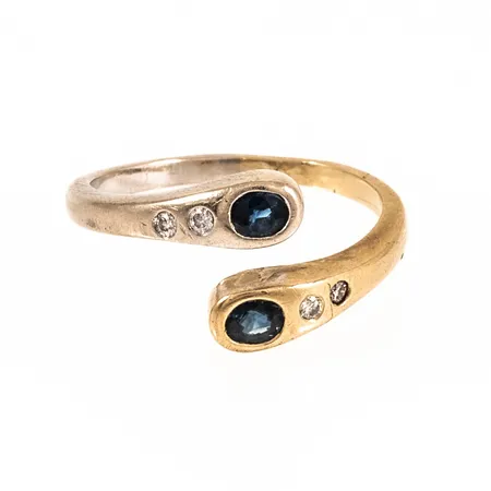 Ring omlott med två blå safirer och 4 x ca 0,015ct briljantslipade diamanter stl:18 bredd 1,8-11,5mm, ojämnheter, spricka i skena, vitguld och rödguld 18K 4,5g.