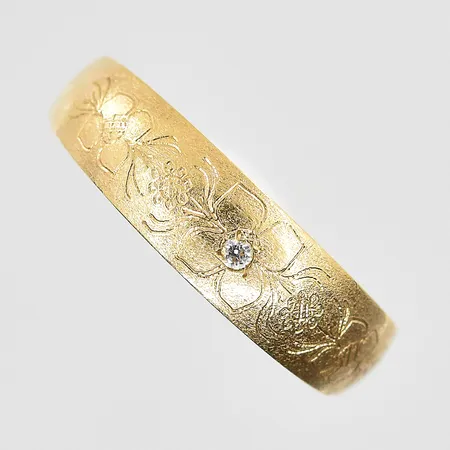 Ring med vit sten och graverat mönster stl 17, bredd 2-5 mm, ojämn skena, 18K. Vikt: 1,5 g