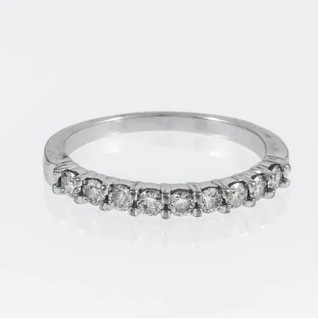 Ring Guldfynd med 9 x ca 0,05ct briljantslipade diamanter stl:18 bredd 1,6-2,8mm, vitguld 18K 3,3g.