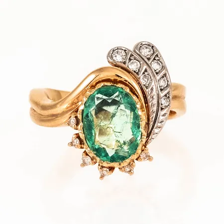 Ring i 18K guld med en smaragd ca 11 x 8,5 mm och briljantslipade diamanter 9 x ca 0,01ct 2 x ca 0,02ct 2 x ca 0,03ct. Stl:17¼. Bredd 4 18,2 mm. Vikt 9,5g Vikt: 9,5 g