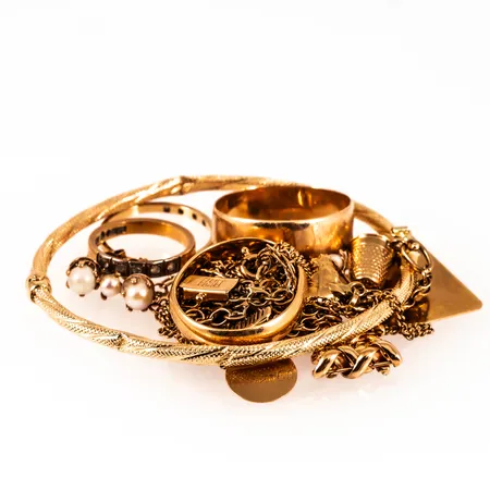 Diverse defekt graverat guld 18K bruttovikt 43,2g.