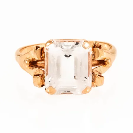 Ring med vit sten (troligen syntetisk spinell) stl:20 bredd 1,8-12mm, naggade fasetter, gravyr, 18K 5,4g. 