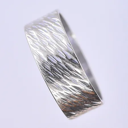 Ring stl:17¼, bredd 7 mm vitguld graverad 18K. Vikt: 4,8 g