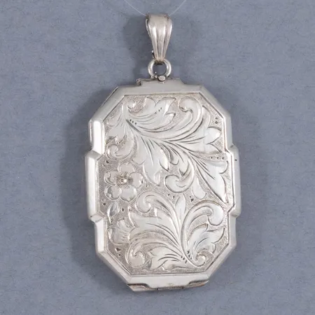 Medaljong med mönstergravyr. Längd 42,3 mm. Bredd 24 mm. Silver 835/1000 8,4g.