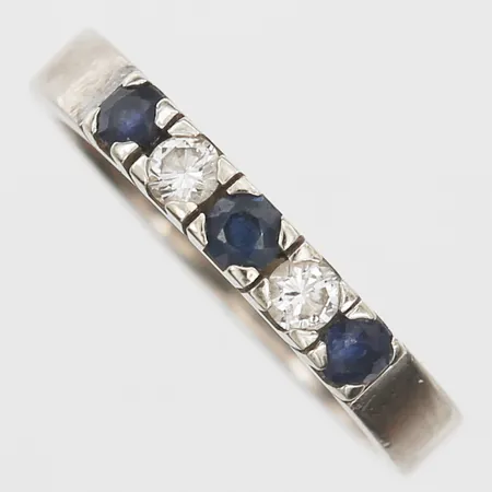 Ring med safirer samt diamanter 0,18ctv enligt gravyr, stl 17¾, bredd 3mm, Hans Strömdahl AB, Stockholm år 1981, repor, vitguld, 18K. Vikt: 5 g