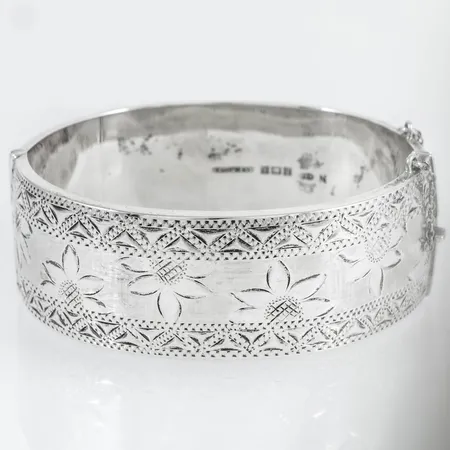 Stelt armband med graverad dekor innermått 18,5cm, bredd 25,5mm, Engelska stämplar Deakin & Francis, Birmingham, 1964. Svag buckla, defekt säkerhetskedja, vaxfylld silver bruttovikt 51,5g.