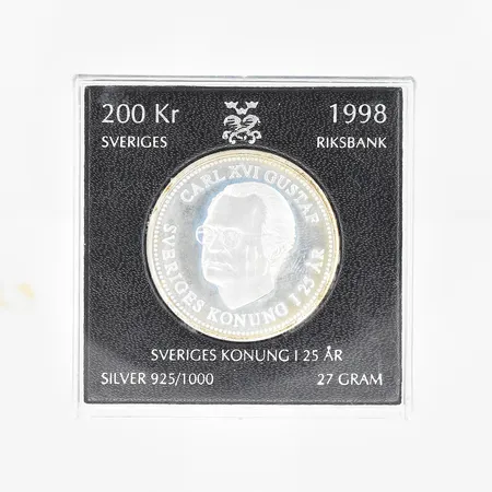 Mynt Carl XVI Gustaf Sveriges konung i 25 år, år 1998, nominellt värde 200kr, silver 925/1000. Vikt: 27 g