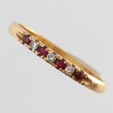 Ring med rubiner 4 x ca 0,02ct samt diamanter totalt 0,09ctv enligt gravyr stl:18½ bredd 2,2mm 18K.  Vikt: 2,1 g