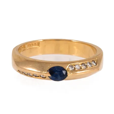Ring med navettslipad blå safir och 10 x 0,01ct briljantslipade diamanter stl:16¾ bredd 3,5-4mm, stenstorlek 0,10ct ingraverad, stämplad S10 (1992), GBON (Guldsmed Björn Nilsson AB, Kristianstad), 18K 4,5g.