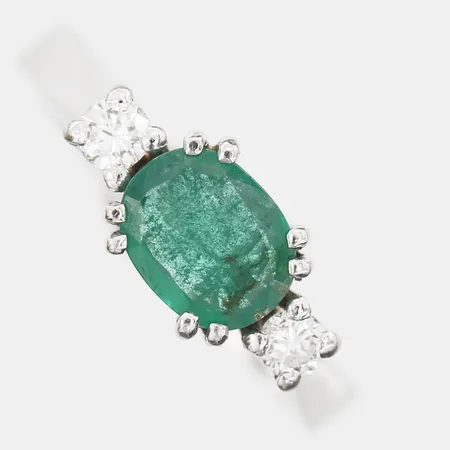 Ring med smaragd ca 0,50ct samt briljantslipade diamanter 2 x ca 0,07ct, stl: 15, tillverkad av Guldsmed Ove Lundgren, Stockholm 1974, 18K vitguld Vikt: 3,6 g