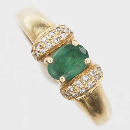 Ring med ovalslipad smaragd samt diamanter 24 x ca 0,005ct, stl 17, bredd 2-6mm, 18K. Vikt: 3,4 g