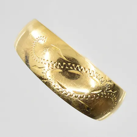 Ring med graverat mönster stl 18¾, bredd 4-7 mm, slitet mönster, 18K. Vikt: 1,9 g