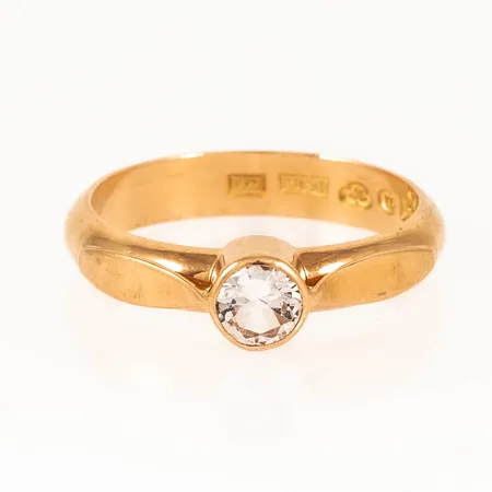 Ring i 18K guld med en vit sten.  Stl:19. Bredd 4,1  5,5 mm. Vikt 5,5g Vikt: 5,5 g
