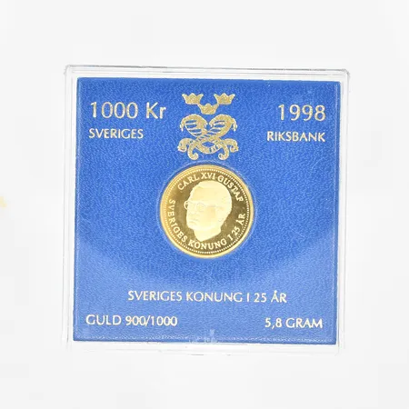 Minnesmynt Carl XVI Gustaf svensk Sveriges Konung i 25 år 1998 Ø21mm, nominellt värde 1000kr, etui Sveriges Riksbank, 21,6K. Vikt: 5,8 g