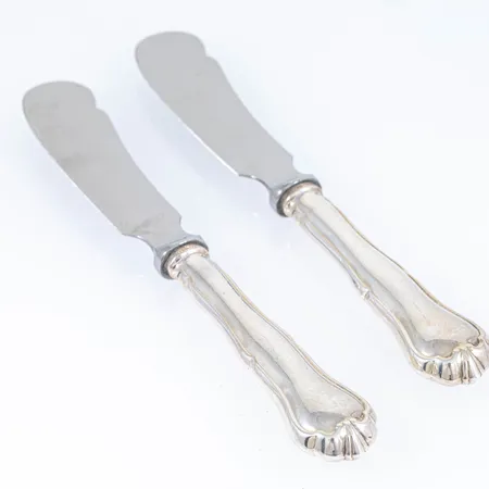 Finsk Chippendale i silver (830/1000) 2 smörknivar med rostfria blad. Finska stämplar med svenska importstämplar. Bruksskick. Vikt 114g bto. 