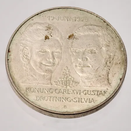 Jubileumsmynt Kungabröllopet 19 juni 1976 Konung Carl XVI Gustav och Drottning Silvia, Ø36mm, nominellt värde 50kr, silver 925/1000, 27 g Vikt: 27 g