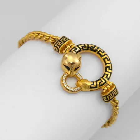 Armband i 18K guld med emalj och vita stenar, ej massiv kedja, ojämnheter / intryckningar i kedjan, tillverkarstämpel YLG, ej finhaltsstämplad, längd 18 cm, kedjans bredd 4,3 mm, tjocklek 2,3 mm, det integrerade hängets bredd 21 mm Vikt: 13,9 g