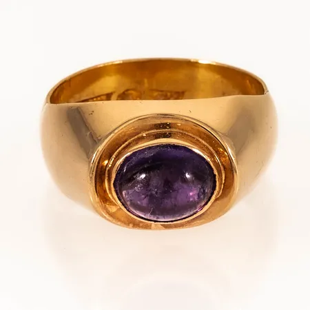 Ring med en cabochonslipad ametist stl:19¼ bredd 6-11,5mm, halvskena i 23K övrigt i 18K, gravyr, 9,9g.