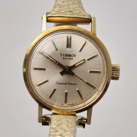 Damur Tissot Seastar Seven i 18K guld, manuell, Ø21mm, flexband i gulmetall, repor på glas, inga tillbehör.