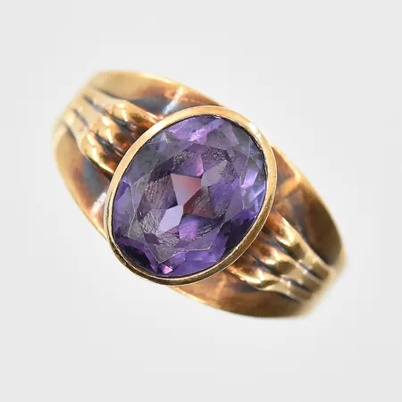 Ring med lila sten stl:18½ bredd 3-10mm, 14K. Vikt: 2,8 g