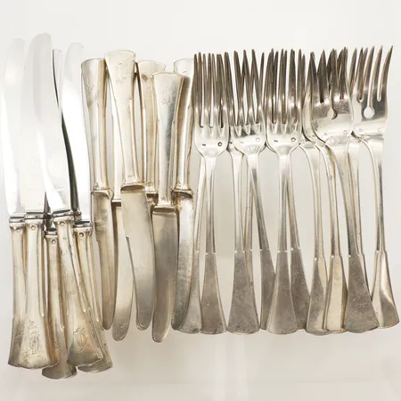 Sju bordsgafflar längd 18cm, fem bordsknivar längd 21cm med blad i rostfritt stål, sex smörgåsknivar längd 17,5cm, fem serveringsgafflar längd 18cm, monogramgravyr, stämplar från Österrike silver 800/1000 bruttovikt: 1144,3g Vikt: 1144,3 g