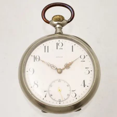 Fickur Omega i vit metall, Ø49mm, boettnummer: 3201975, personlig gravyr, spricka i emalj, går ej att vrida upp.
